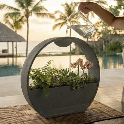 3D-printed stone-textured self-watering flower pot.