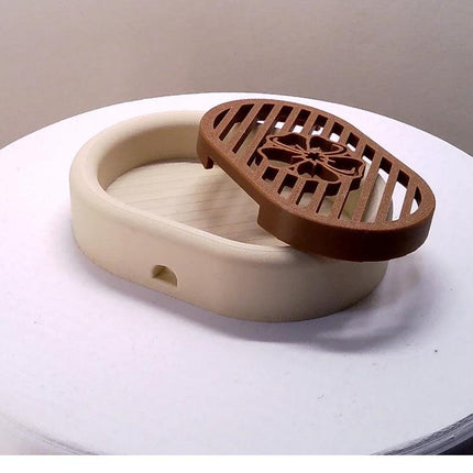 3D-printed oval soap dish with drain rack, white and wood-look..