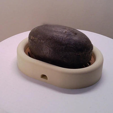 3D-printed oval soap dish with drain rack, white and wood-look..