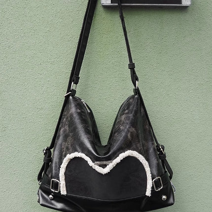Stylish black tote backpack with heart embellishment - can be worn on one shoulder or as a backpack.