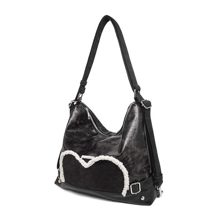 Stylish black tote backpack with heart embellishment - can be worn on one shoulder or as a backpack.