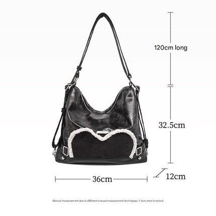 Stylish black tote backpack with heart embellishment - can be worn on one shoulder or as a backpack.