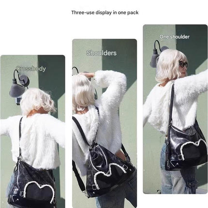 Stylish black tote backpack with heart embellishment - can be worn on one shoulder or as a backpack.