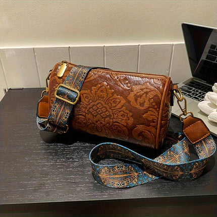 Black Vintage Embossed Crossbody Barrel Bag with Wide Adjustable Guitar Strap.
